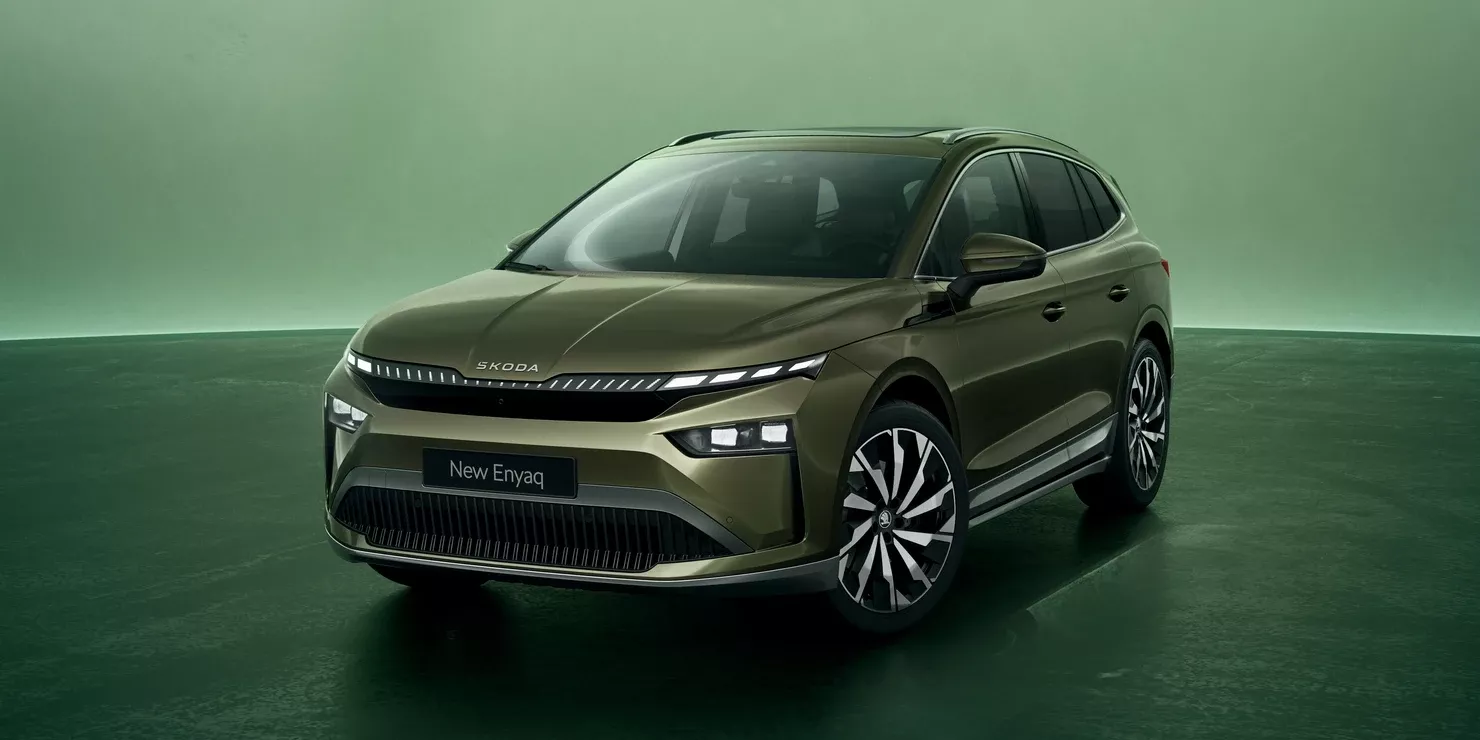 Ein Skoda Enyaq in einem grünen Farbton steht auf einem dunklen Untergrund.