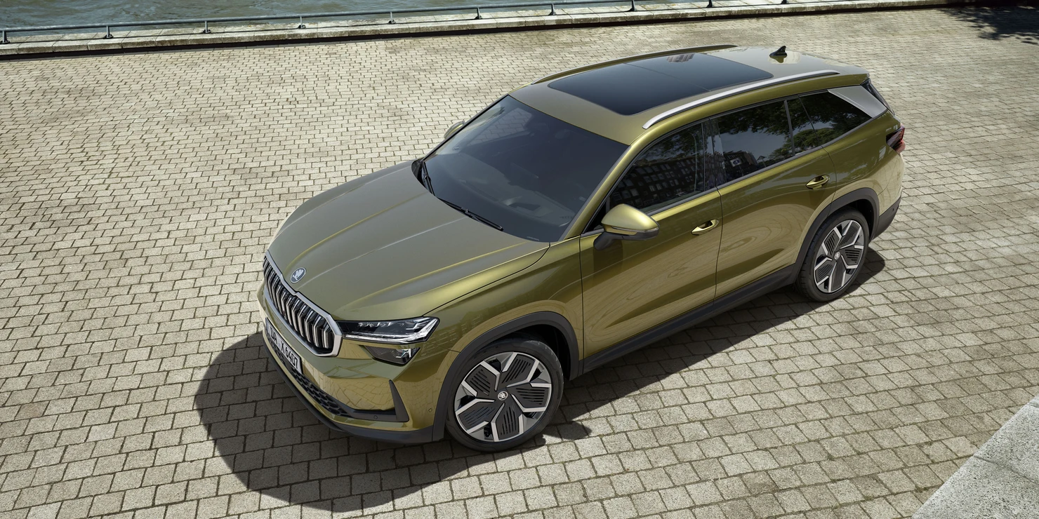 Ein grüner Škoda Kodiaq steht auf einem gepflasterten Platz.