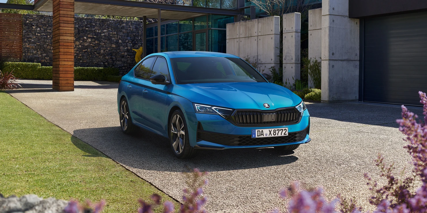 Ein blauer Škoda Octavia Sportline steht in einer modernen Einfahrt.