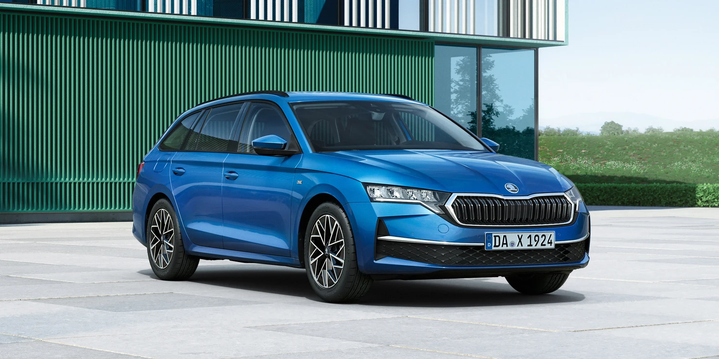 Ein blauer Škoda Octavia Combi Tour steht vor einem modernen Gebäude.