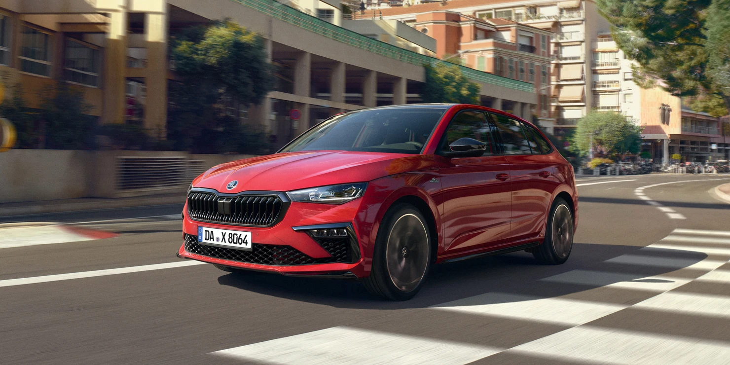Ein roter Škoda Scala Monte Carlo fährt durch eine städtische Umgebung.