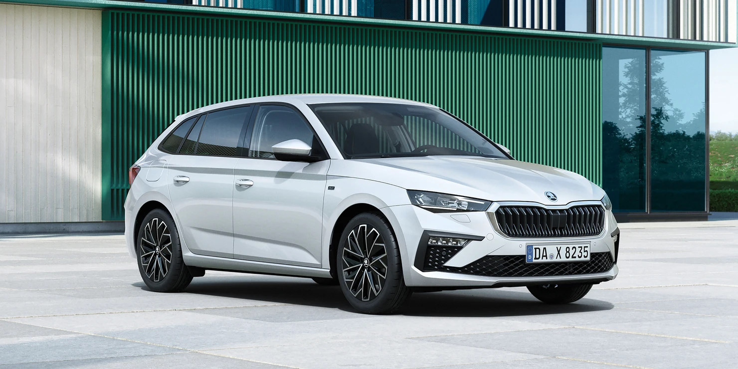 Ein silberner Skoda Scala steht vor einem modernen Gebäude.