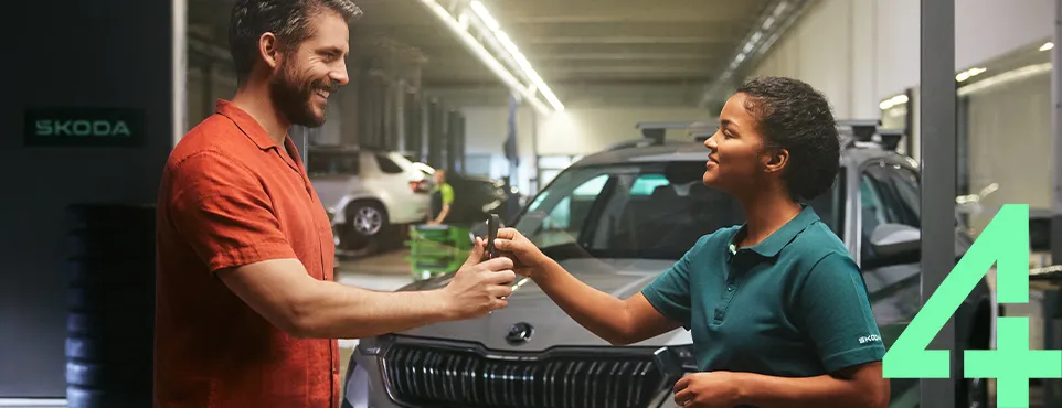 20250407_850.300_20250404_V0_1_SAD_SER_CS_HPP_Teaser_962x370_Qualitaet_v1 Ein Mann übergibt einer Frau in einer Werkstatt die Autoschlüssel eines Škoda.