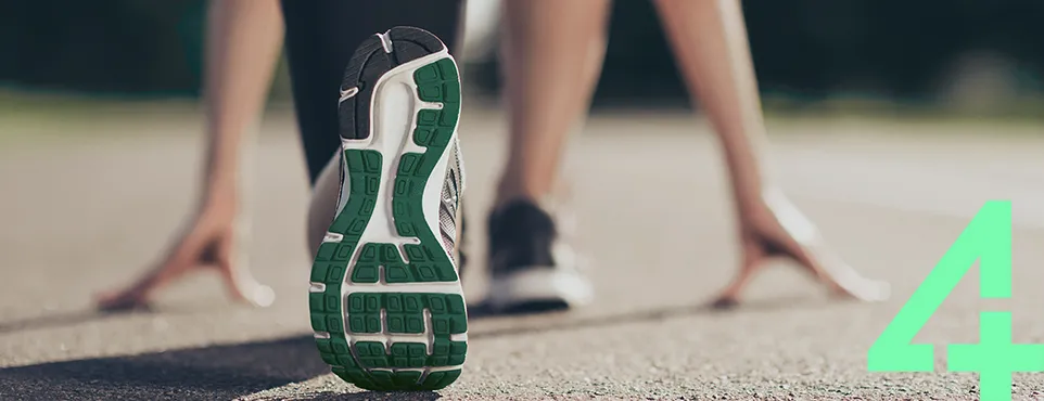 850.190_SAD_Clever_Service_Teaser_962x370_Starter4_271023 Eine Person in Startposition beim Laufen, Fokus auf den Schuh mit grüner Sohle.