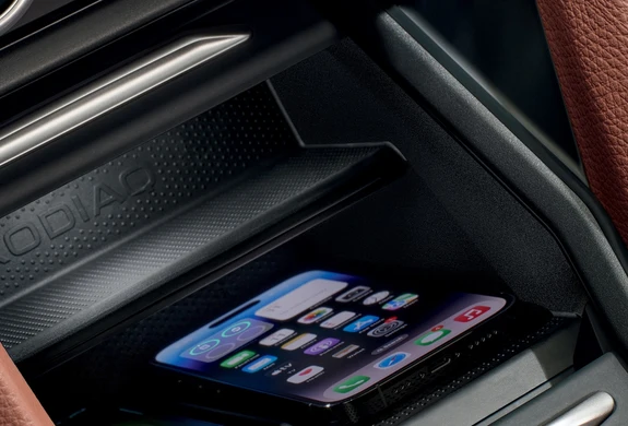 Kodiaq-Ausstattung_bp320 Ein Smartphone liegt in einem Autoablagefach mit der Aufschrift "KODIAQ".