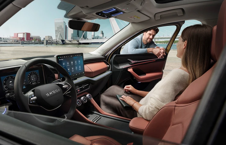 Kodiaq-gg_bp1920_3 Ein Mann spricht mit einer Frau im Innenraum eines Škoda Kodiaq.