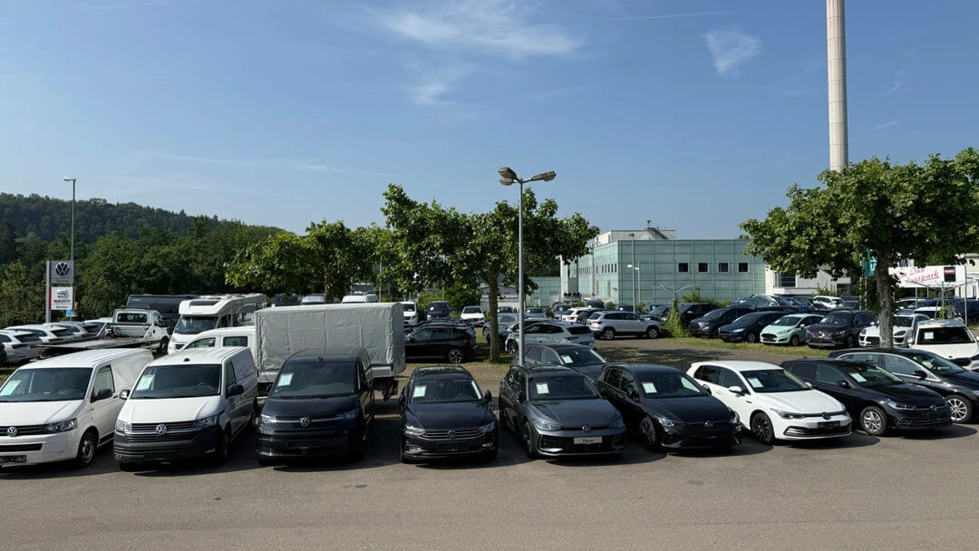 fahrzeugbestand-Teaser Ein Parkplatz voller Volkswagen-Fahrzeuge vor einem Autohaus.