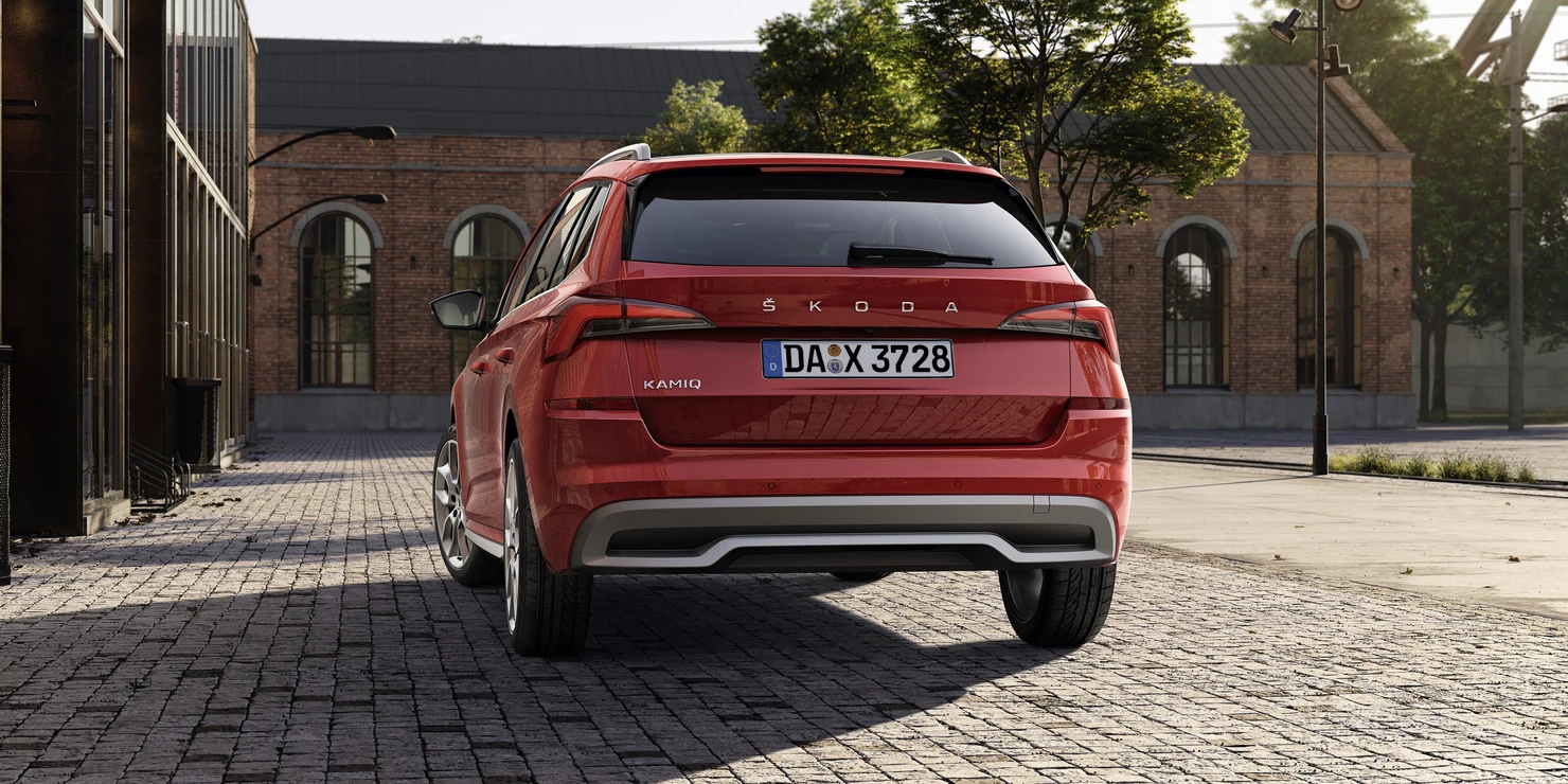 Rotes Škoda Kamiq Auto von hinten in einer städtischen Umgebung.