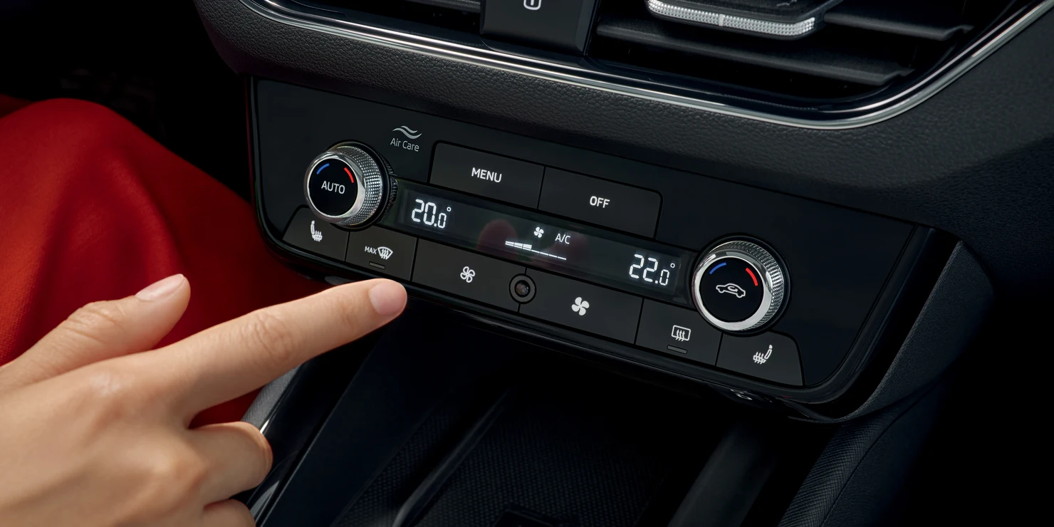 kamiq_ausstattung-1 Eine Hand bedient die Klimaanlage eines Škoda Kamiq.