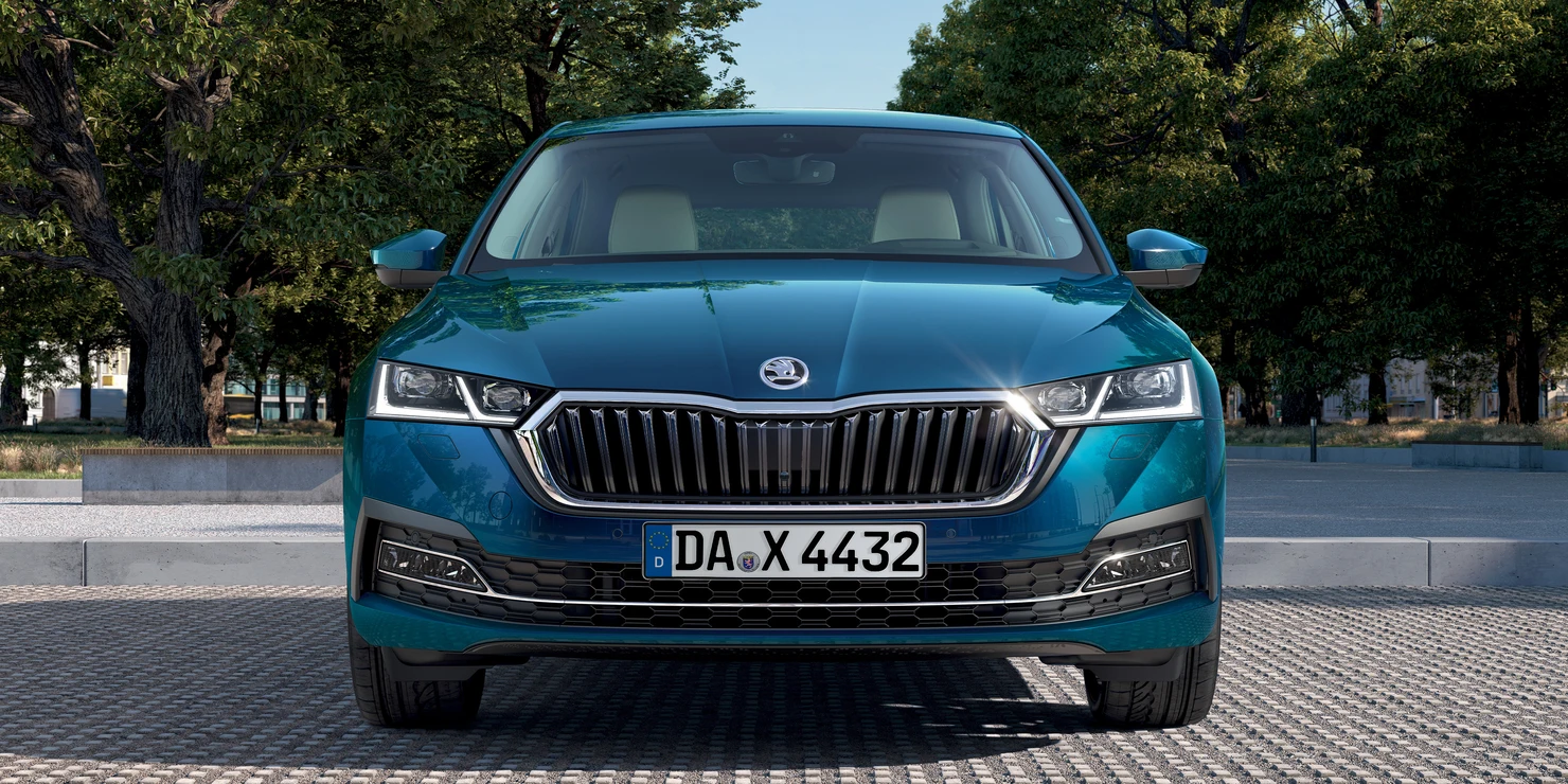 octavia Ein blauer Skoda Octavia steht auf einer gepflasterten Fläche vor Bäumen.