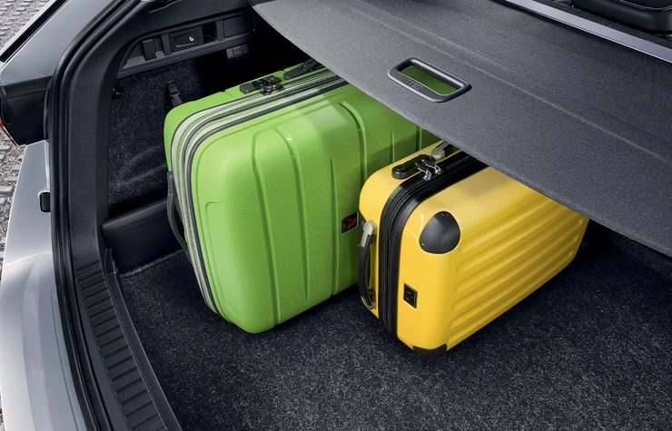 octavia_combi-gg-01 Zwei Koffer, einer grün und einer gelb, im Kofferraum eines Autos.
