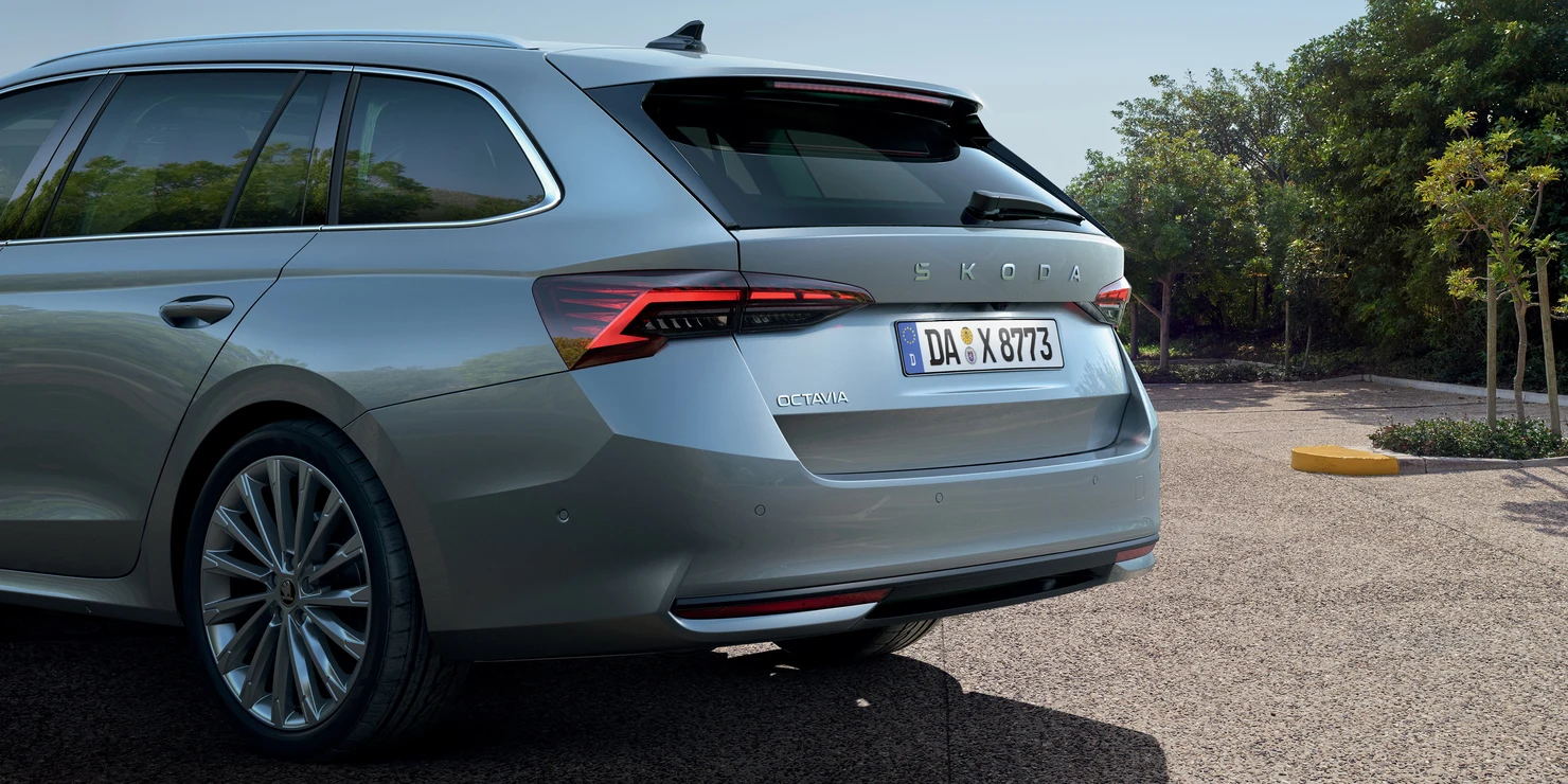 Heckansicht eines silbernen Škoda Octavia Kombi 2025 auf einem Parkplatz.