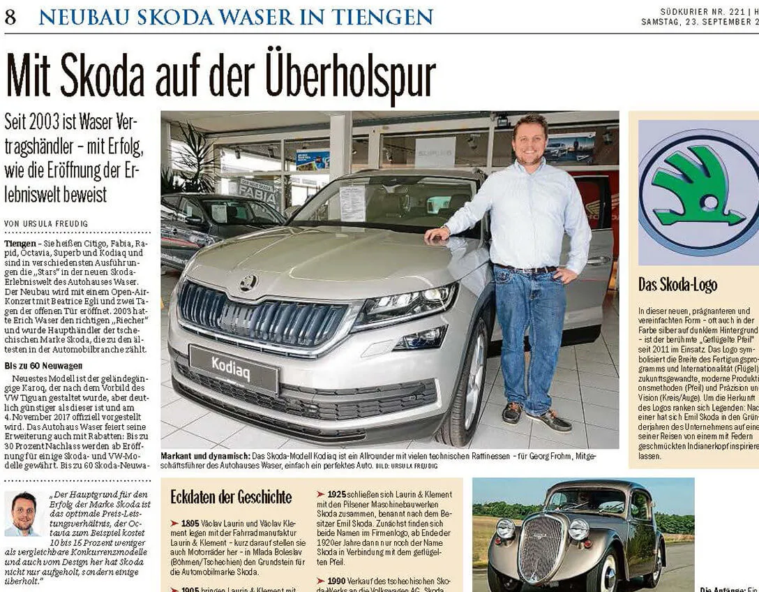 Ein Mann steht neben einem silbernen Skoda Kodiaq in einem Autohaus.