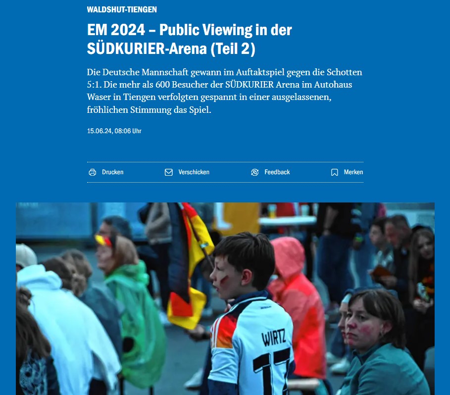 Junge mit Deutschlandtrikot hält eine Flagge beim Public Viewing.