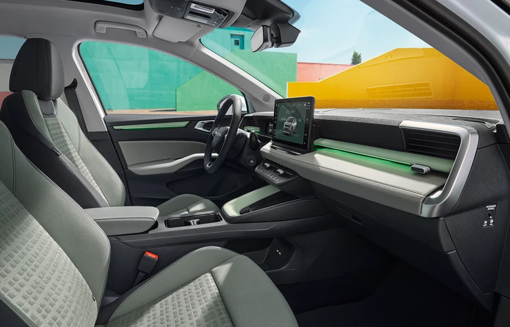 Innenraum eines modernen Fahrzeugs mit grünem Akzent und zentralem Display.