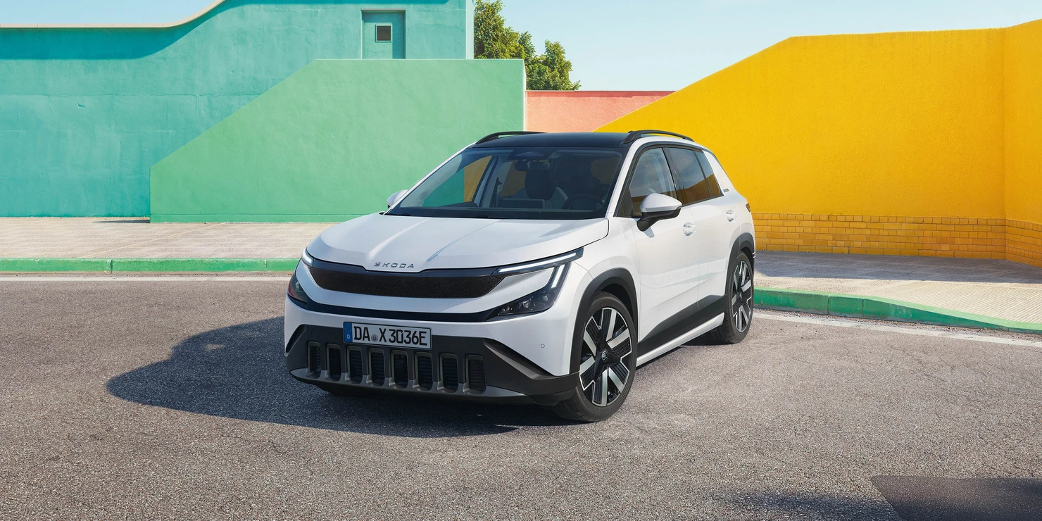Ein weißer Skoda Epiq steht vor bunt bemalten Wänden.