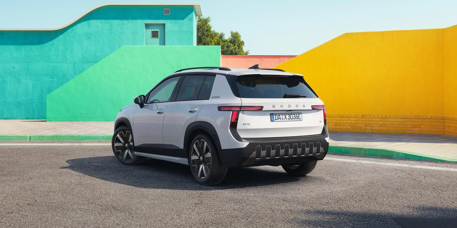 Ein silberner Škoda Epiq SUV steht vor bunten Wänden.
