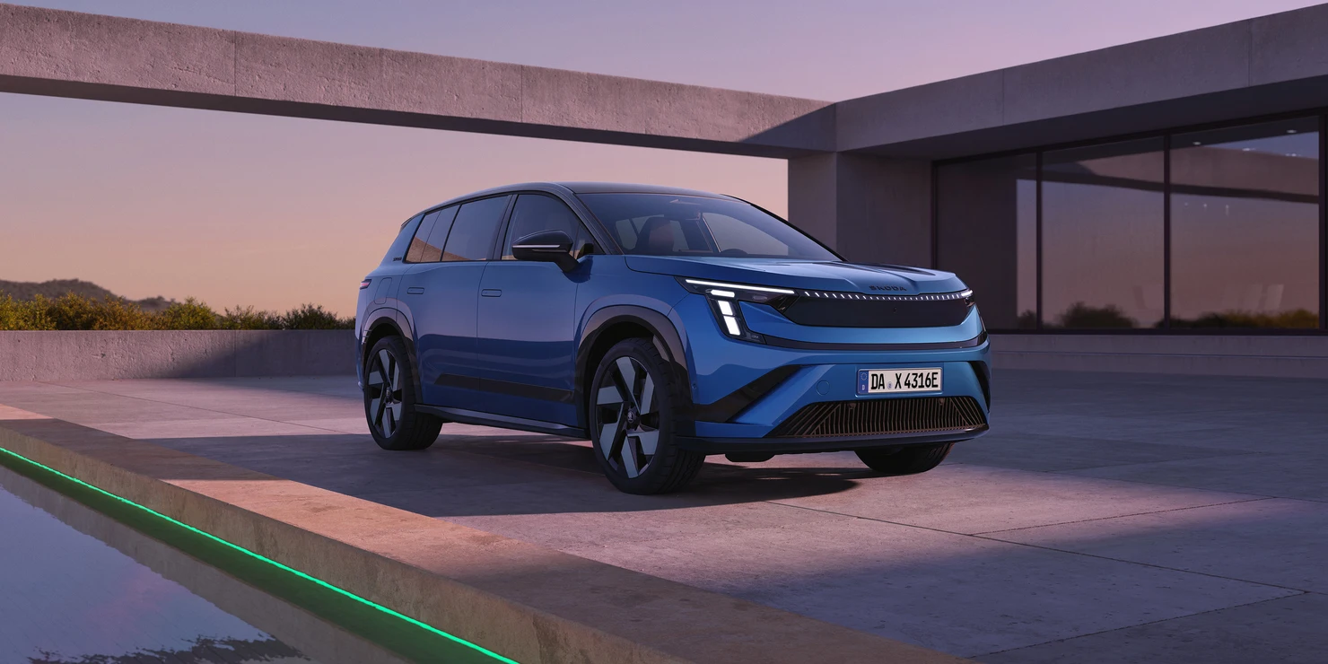 Ein blauer Skoda SUV steht auf einer modernen Terrasse bei Sonnenuntergang.